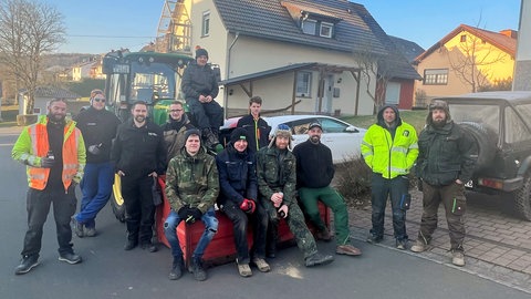 Viele Menschen helfen beim Hüttenbrennen in Bickendorf in der Eifel mit.