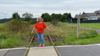 Andrea Horst kann gefahrlos auf den Zuggleisen stehen, denn durch Höchstberg in der Eifel ist schon seit über zehn Jahren kein Zug mehr gefahren.