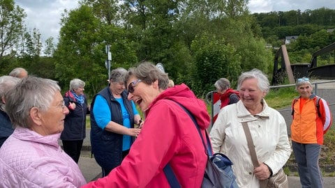 Bewegungsbegleiterin Dorothea Klug (Mitte) begrüßt eine der Teilnehmerinnen am Plauderspaziergang. Gleich werden sie gemeinsam Spazieren und dann Bewegungsübungen machen.