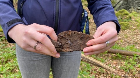 Es gibt auch einen nicht-vulkanischen Fund auf dieser Schatzsuche: Ein rostiges Stück Eisen mit Nägeln. Vielleicht von einem Werkzeug, um den Stein zu behauen? Geologin Kummer nimmt es mit, um es zu untersuchen. Wie sich herausstellt, dürfte es sich dabei um den Klauenbeschlag eines Ochsen aus der Zeit des Abbaus handeln.