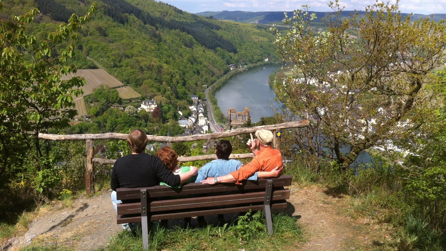 Wanderer sitzen auf einer Bank bei Grevenburg und schauen auf die Mosel.