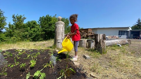 Die siebenjährige Marie hat im Projekt gelernt, wie wichtig es ist, neu gepflanzte Blumen anzugießen.