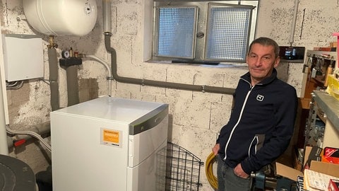 Haus-Eigentümer Peter Hansen vor seiner neuen Wärmepumpe im Keller.