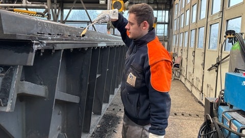 Adrian Gliedner arbeitet beim Wasserstraßen und Schifffahrtsamt als Feinwerkmechaniker. Er streicht die Schrauben mit einem wasserfesten Lack ein.