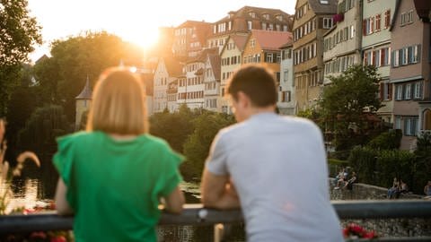 Ein Paar schaut in Tübingen vor Altstadt-Kulisse in den Sonnenuntergang