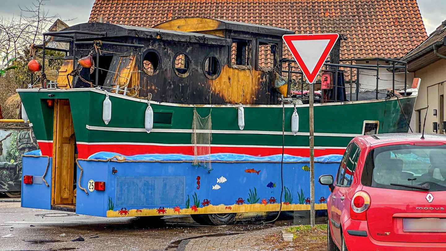 Ausgebrannter Motivwagen mit verkohltem Aufbau