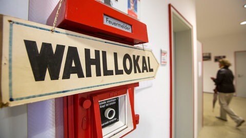 Ein Schild weist den Weg zu einem Wahllokal.