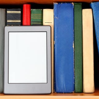 Ebook-Reader vor einer bunten Bücherwand