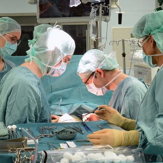 Zwei Ärzte (Mitte) arbeiten im Transplantationszentrum am Universitätsklinikum bei einer Operation
