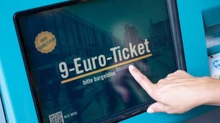 Eine Frau zieht sich an einem Fahrschein-Automaten ein 9-Euro-Ticket