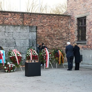 Bundespräsident Frank-Walter Steinmeier und Ehefrau Elke Büdenbender legen an der Todeswand im KZ Auschwitz einen Kranz nieder. 