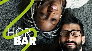 ARD Radiofestival 2024 Hörbar - Eine Frau und ein Mann liegen auf dem Fußboden und hören Musik.