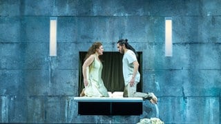 Verdis "Otello" am Theater Ulm: Desdemona (Maryna Zubko) und Otello (Rodrigo Porras Garulo) kniend auf ihrem Brautbett. Sie schauen einander an.