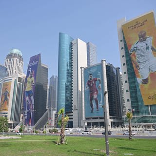Riesige Banner mit Fußballstars bedecken die Fasaden von Wolkenkratzern in Doha, Katar