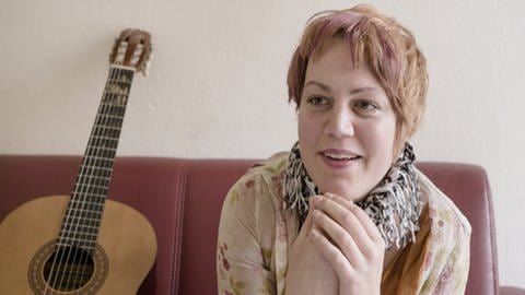 Simone mit Gitarre im Film "IRRE oder Der Hahn ist tot"