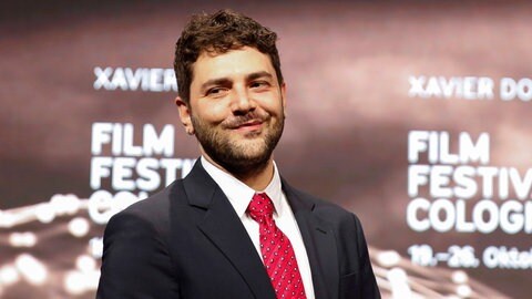 Xavier Dolan posiert mit seiner Trophäe beim Kölner Filmfestival