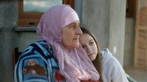 Filmszene "Echoes from Borderland" bosnische Bäuerin mit Kopftuch, Mädchen lehnt sich an ihre Schulter