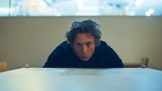 Carmy (Jeremy Allen White) blickt prüfend über die Kante eines Tisches.