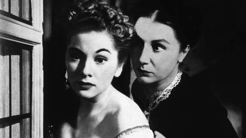 Szene aus "Rebecca": Mrs. de Winter (Joan Fontaine) blickt verängstigt aus dem Fenster. Sie wird bedrängt von der Haushälterin Mrs. Danvers (Judith Anderson).