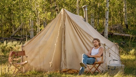 „Yellowstone“: Kayce sitzt vor einem Zelt