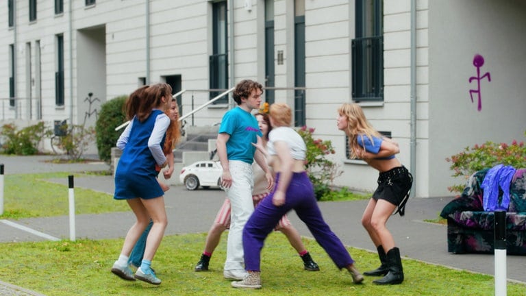 Filmstill: Ein junger Mann ist umgeben von Frauen, die ihn angreifen. 