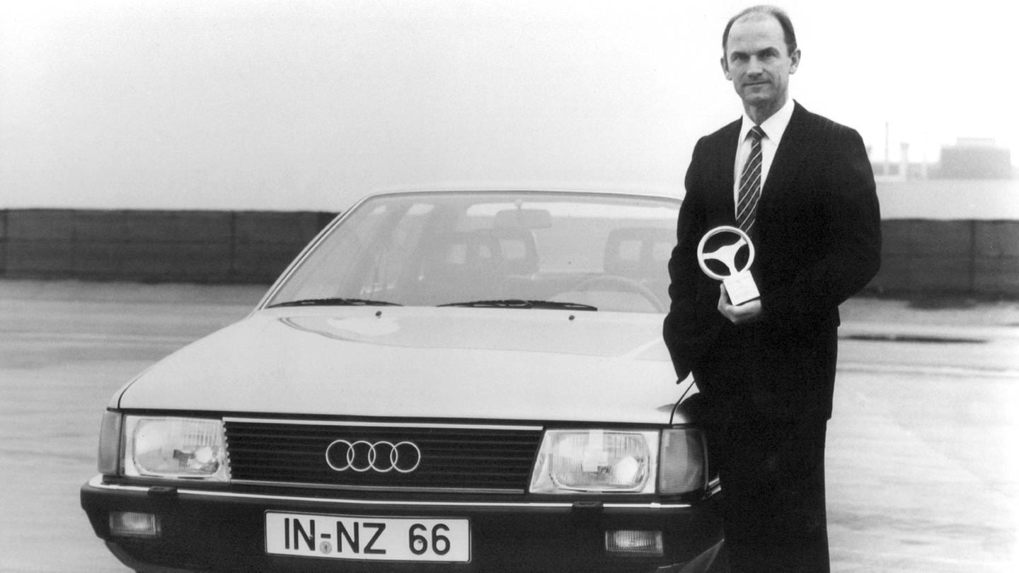 Audi-Vorstandsmitglied (Technische Entwicklung) Ferdinand Piëch Anfang der Achtzigerjahe mit einem Goldenen Lenkrad in der Hand neben einem Audi 100.