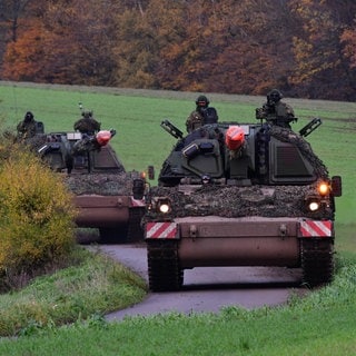 Zwei Panzer auf einer kleinen Straße