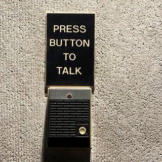 Sprechanlage mit einem Schild "press button to talk"