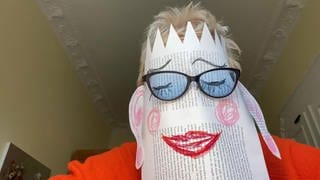 Doris Dörrie mit Papiermaske und Brille