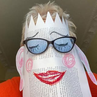 Doris Dörrie mit Papiermaske und Brille