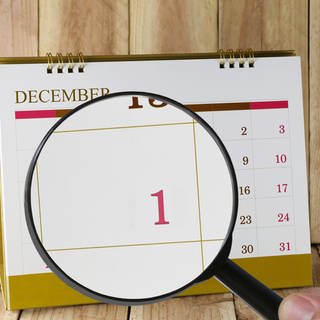 Tischkalender, eine Lupe zeigt vergrößert den 1. Dezember