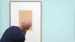 Ein Besucher betrachtet das Bild 'Unter grossem Hut'  vom Deutsch-Schweizer Maler Paul Klee 