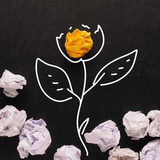Papierknäuel auf einer gezeichneten Pflanzenblüte (Zeichnung ist mit weißen Konturen auf schwarzes Papier gezeichnet.) 