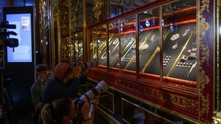 Fotografen stehen im Rahmen eines Pressetermins der Staatlichen Kunstsammlungen Dresden (SKD) zur Präsentation der zurückerlangten Juwelen im Historischen Grünen Gewölbe im Residenzschloss vor der Vitrine. 