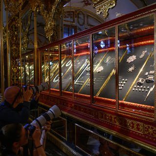 Fotografen stehen im Rahmen eines Pressetermins der Staatlichen Kunstsammlungen Dresden (SKD) zur Präsentation der zurückerlangten Juwelen im Historischen Grünen Gewölbe im Residenzschloss vor der Vitrine. 