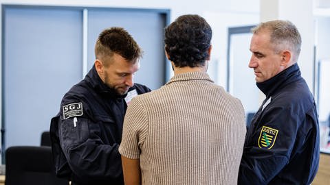 Einer der Angeklagten von hinten im Gerichtssaal des Landgerichts Dresden.