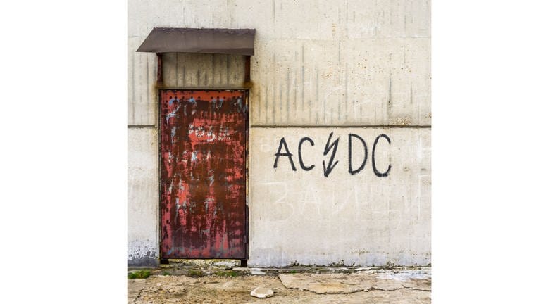 An einer Hauswand steht der Bandname ACDC.