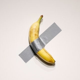 Kunstwerk von Maurizio Cattelan: Eine Banane klebt mit Klebeband an der Wand.