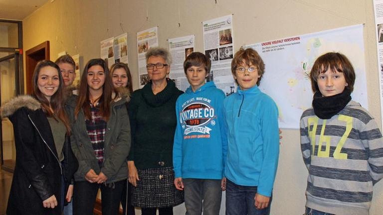 Schüler und ihre Lehrerin posieren für ein Gruppenfoto