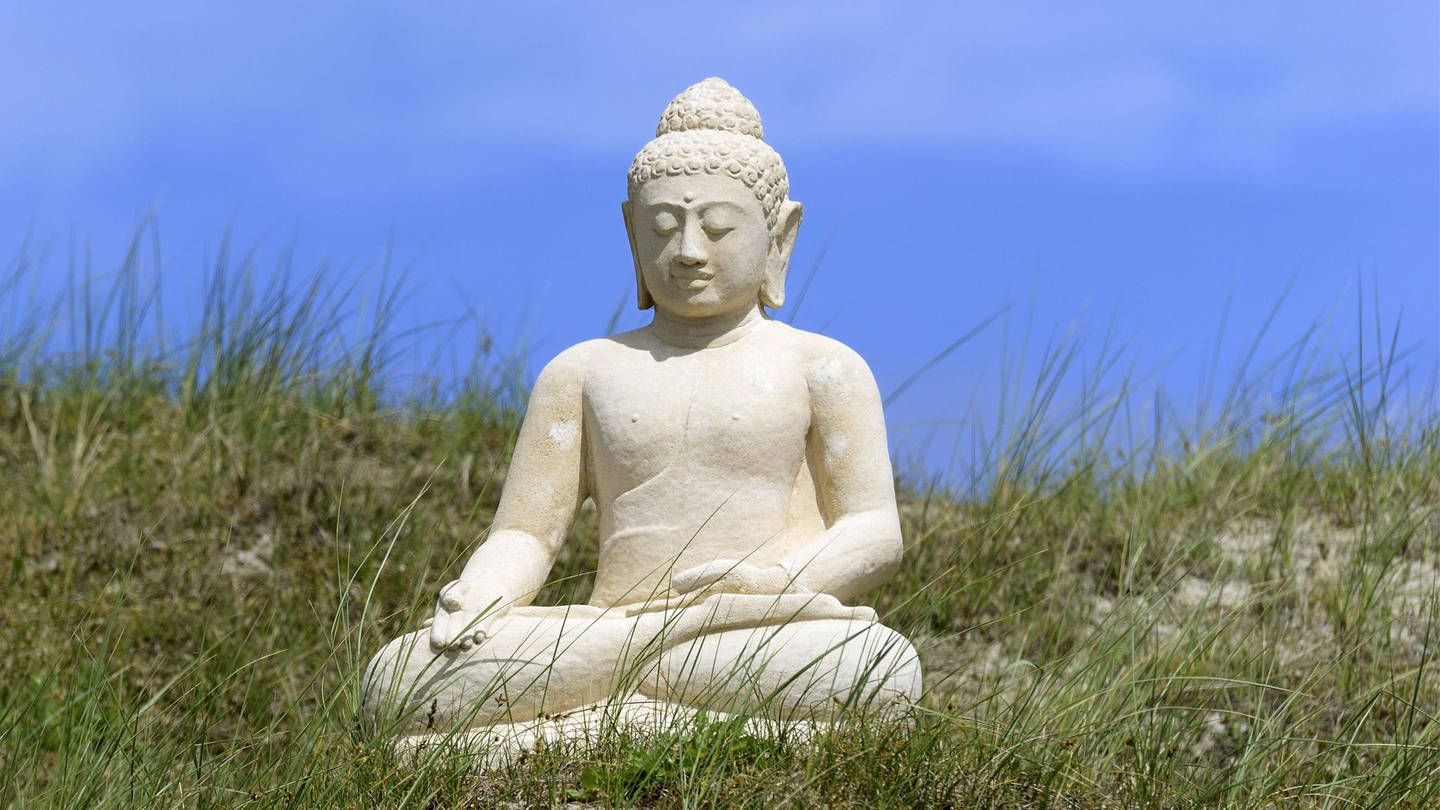 Eine Buddha-Skulptur in der Dünenlandschaft von Norderney