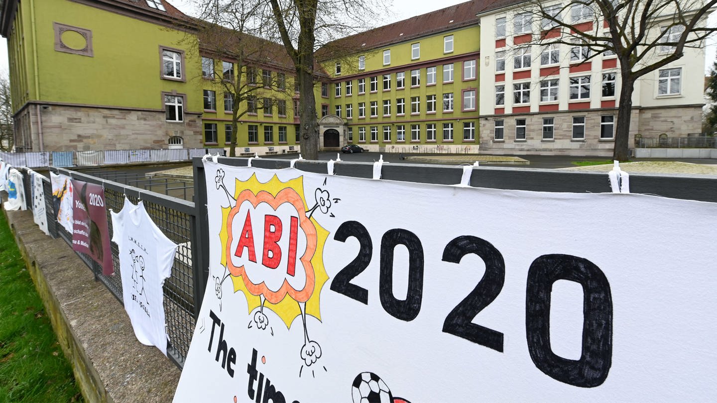 „Abi 2020” steht auf einem selbst gemalten Abi-Plakat, das vor einer Schule aufgehängt ist