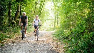 Paar fährt mit dem Fahrrad durch den Wald