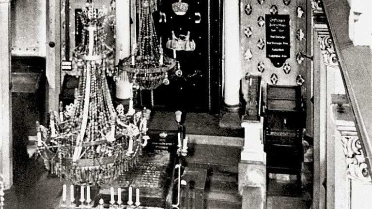 Die Kippenheimer Synagoge 1936, zwei Jahre vor der Zerstörung, mit dem Thoraschrain, der sechs Thorarollen enthält. Der Schrain ist verdeckt durch den geschmückten Thoravorhang, vorne die große Menora. Dieses Bild hängt heute als Großformat in der Synagoge, dort, wo sich der Thoraschrein befand.
