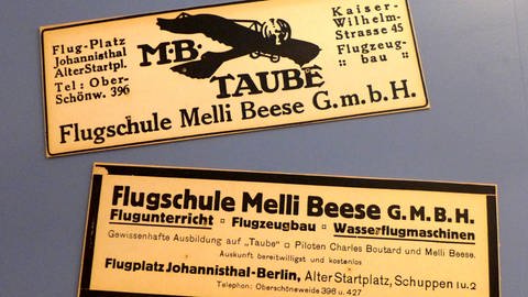 Zusammen mit ihrem Mann Charles Boutard startet Melli Beese eine eigene Flugschule: Zwei Zeitungsannoncen, die die Kursprogramme der Flugschule Melli Beese GmbH kurz angeben.