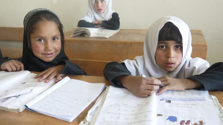 Bild von Kindern im Klassenzimmer. Mädchen dürfen bis zur 6. Klasse wieder zur Schule gehen.