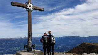 Mutter und Tochter Wächter am Ziel: Das Gipfelkreuz Goldeck auf 2.050 Meter Höhe 