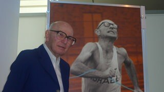 Ladany vor seinem Poster von den Olympischen Spielen 1972 in München, an denen er als Geher teilnahm.