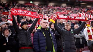 Liverpooler Fußballfans singen mit erhobenen Team-Schals