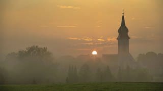 Sonnenaufgang in Rottenbuch hinter der Kirche Mariä Geburt, Kreis Weilheim-Schongau, Bayern