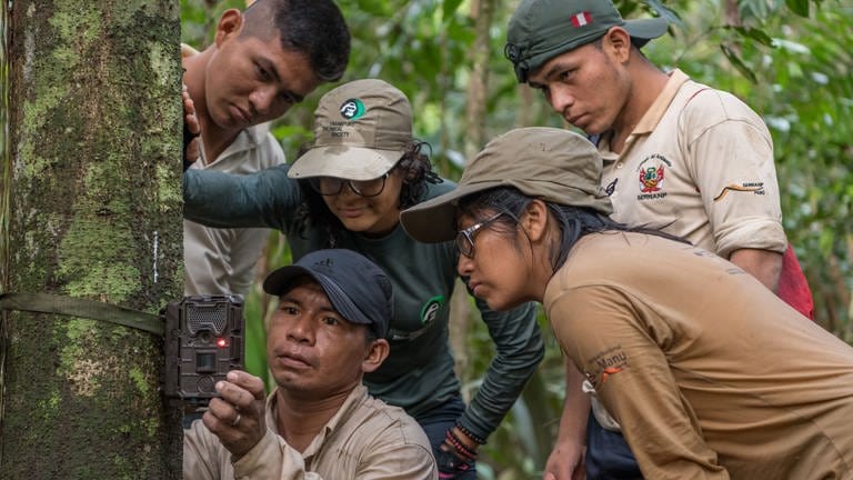 Mónica Paredes Obando, FZS-Mitarbeiterin in Iquitos, erklärt SERNANP-Parkwächtern den Einsatz der Trail-Kamera